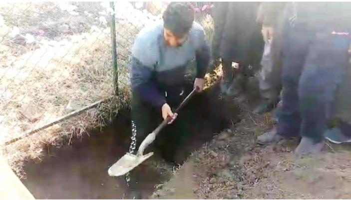 Athar's father while digging grave for his son.