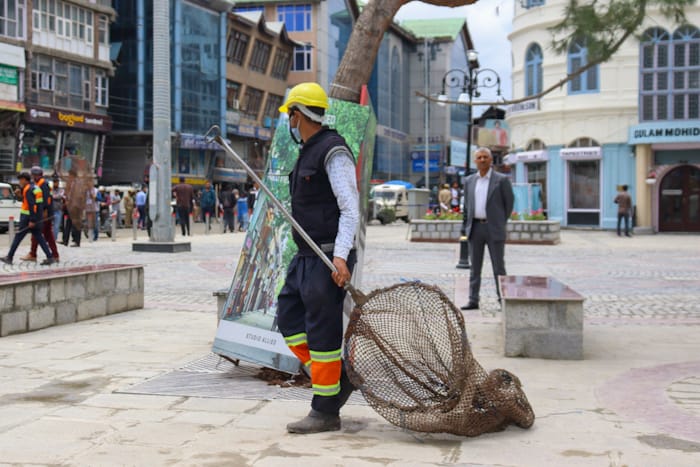 An employee of muncipal council holding a net to trap dogs stands deployed at newly renovated Polo View market as G20 delegates are likely to visit the area on May 24, 2023. [FPK Photo/ Umar Farooq]